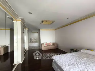 Spacious bedroom with elegant decor and cozy seating area