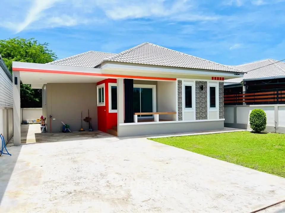 Modern single-story house with spacious driveway and lush green lawn.