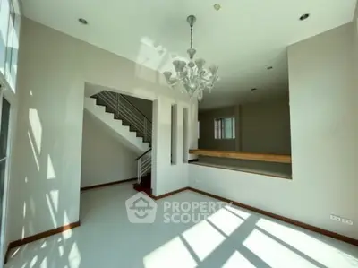 Spacious modern living room with elegant chandelier and natural light