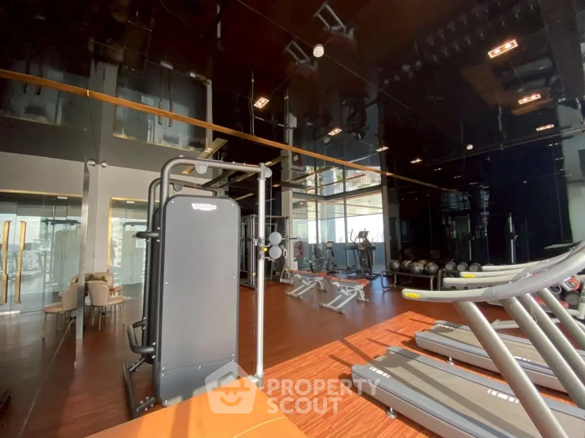 Modern gym with state-of-the-art equipment and sleek design in luxury residential building.
