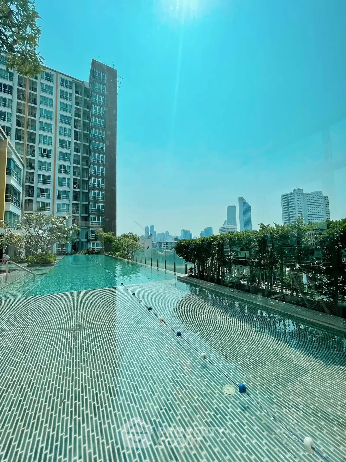 Luxurious high-rise apartment with stunning rooftop pool and city skyline view.