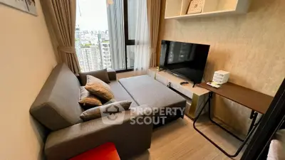 Modern living room with city view, featuring a cozy sofa and sleek TV setup.