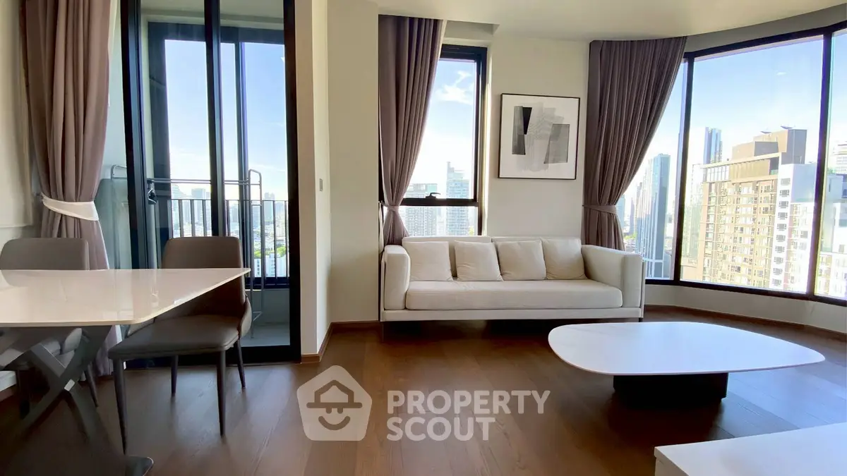 Modern living room with city view, elegant furniture, and large windows for natural light.