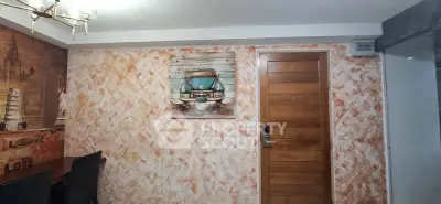 Stylish dining area with artistic wall decor and wooden door, perfect for modern living.
