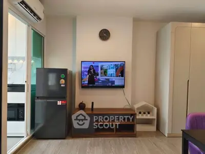 Modern living room with TV, fridge, and stylish decor