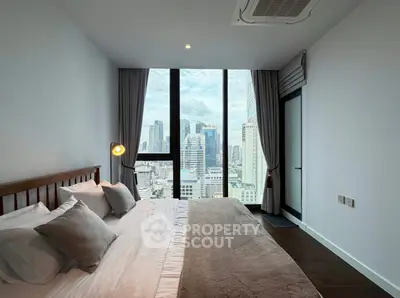 Luxurious bedroom with stunning city view and modern decor in high-rise apartment.