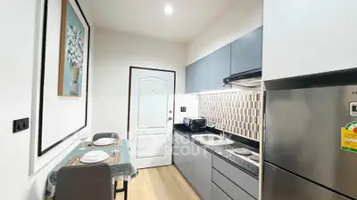 Modern kitchen with sleek cabinetry and dining area in compact layout