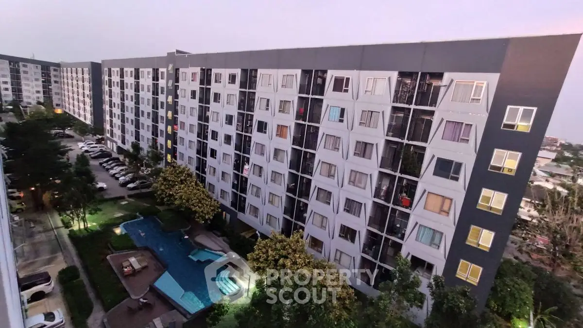 Modern apartment complex with pool and lush greenery, offering urban living with resort-style amenities.