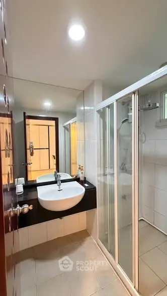 Modern bathroom with sleek shower and elegant sink in a contemporary home.