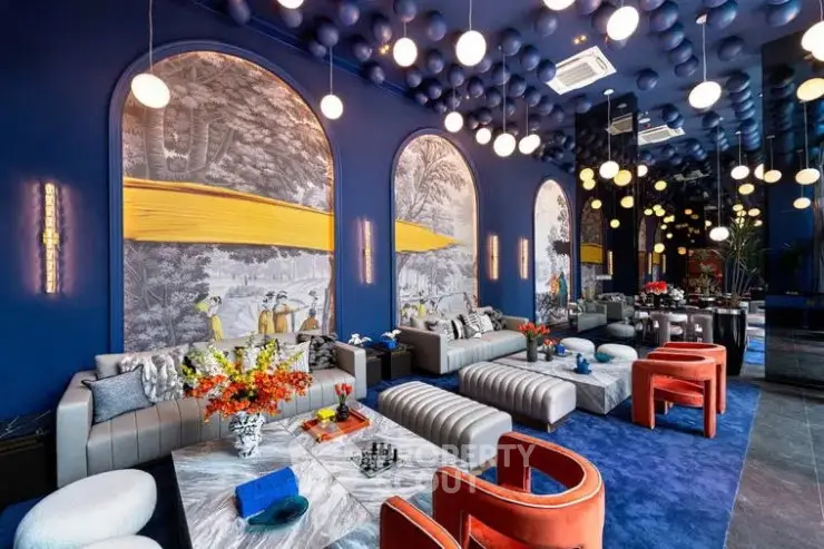 Luxurious modern living room with vibrant blue walls, elegant lighting, and stylish furniture.