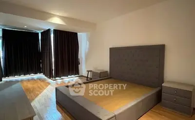 Spacious bedroom with modern design and large windows for natural light.