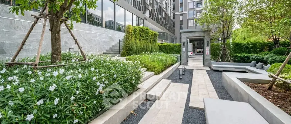 Modern apartment building with lush landscaped garden and sleek architectural design.