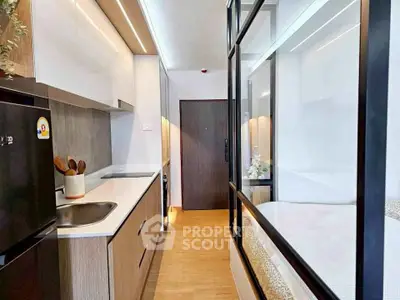 Modern compact kitchen with sleek design and integrated appliances in a stylish apartment.