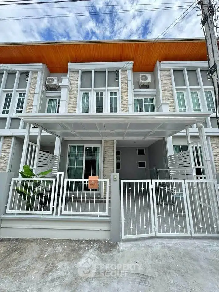 Modern townhouse exterior with sleek design and gated entrance, perfect for urban living.