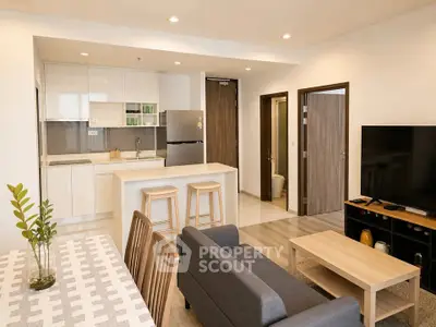 Modern open-plan living room and kitchen with stylish furniture and neutral tones.