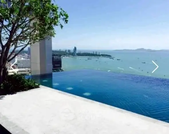 Stunning infinity pool with breathtaking ocean view in luxury high-rise building.