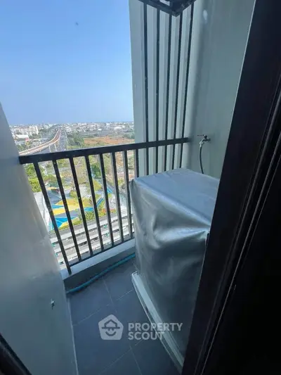 Compact balcony with city view and washing machine setup, ideal for urban living.