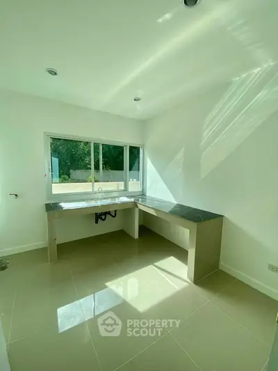 Bright modern kitchen with large window and sleek countertops