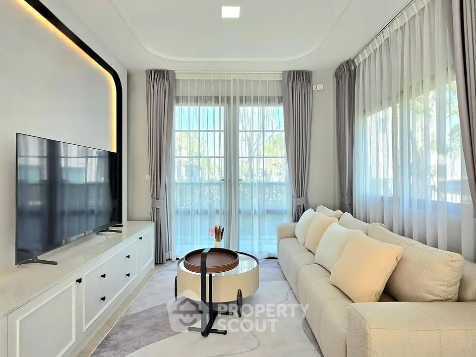 Elegant living room with modern decor, large windows, and a cozy sofa, perfect for relaxation and entertainment.