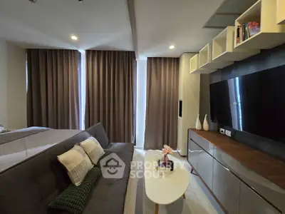 Modern living room with sleek furniture and large TV, perfect for relaxation and entertainment.