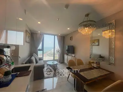 Luxurious living room with ocean view, elegant chandelier, and modern decor in a high-rise apartment.