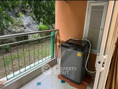 Cozy balcony with washing machine and garden view, perfect for urban living.