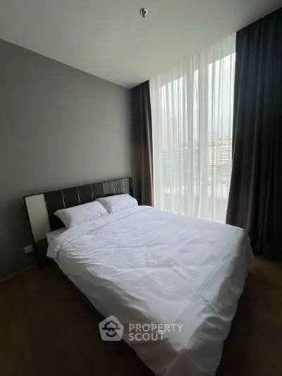 Modern bedroom with large window and stylish decor in urban apartment