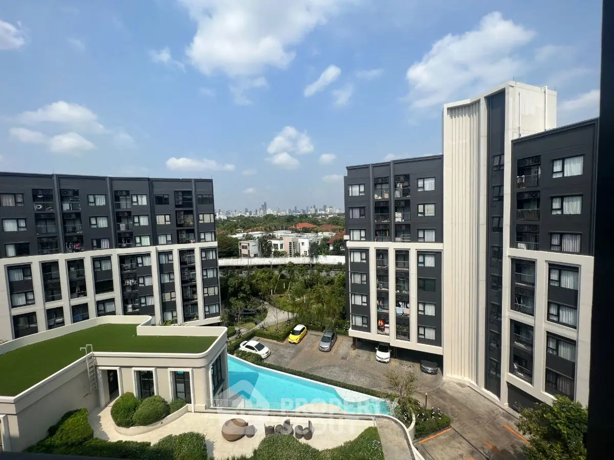 Modern apartment complex with pool and city skyline view