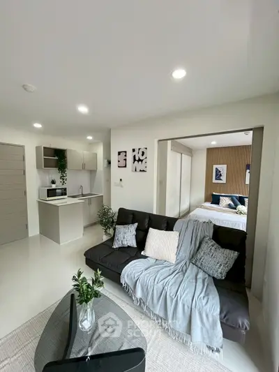 Modern open-plan living room with cozy sofa and stylish kitchen area