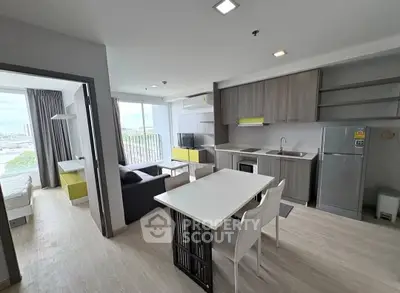 Modern open-plan living room and kitchen with balcony view in stylish apartment