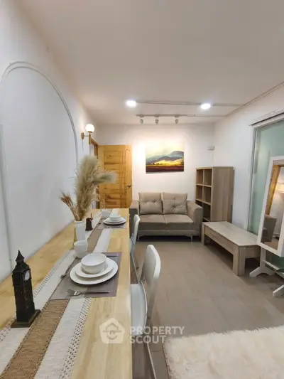 Charming living room with cozy decor and elegant dining setup, perfect for modern living.