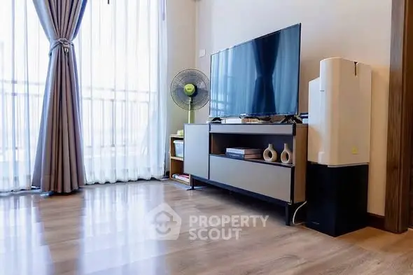 Modern living room with sleek TV stand, large window, and elegant curtains.