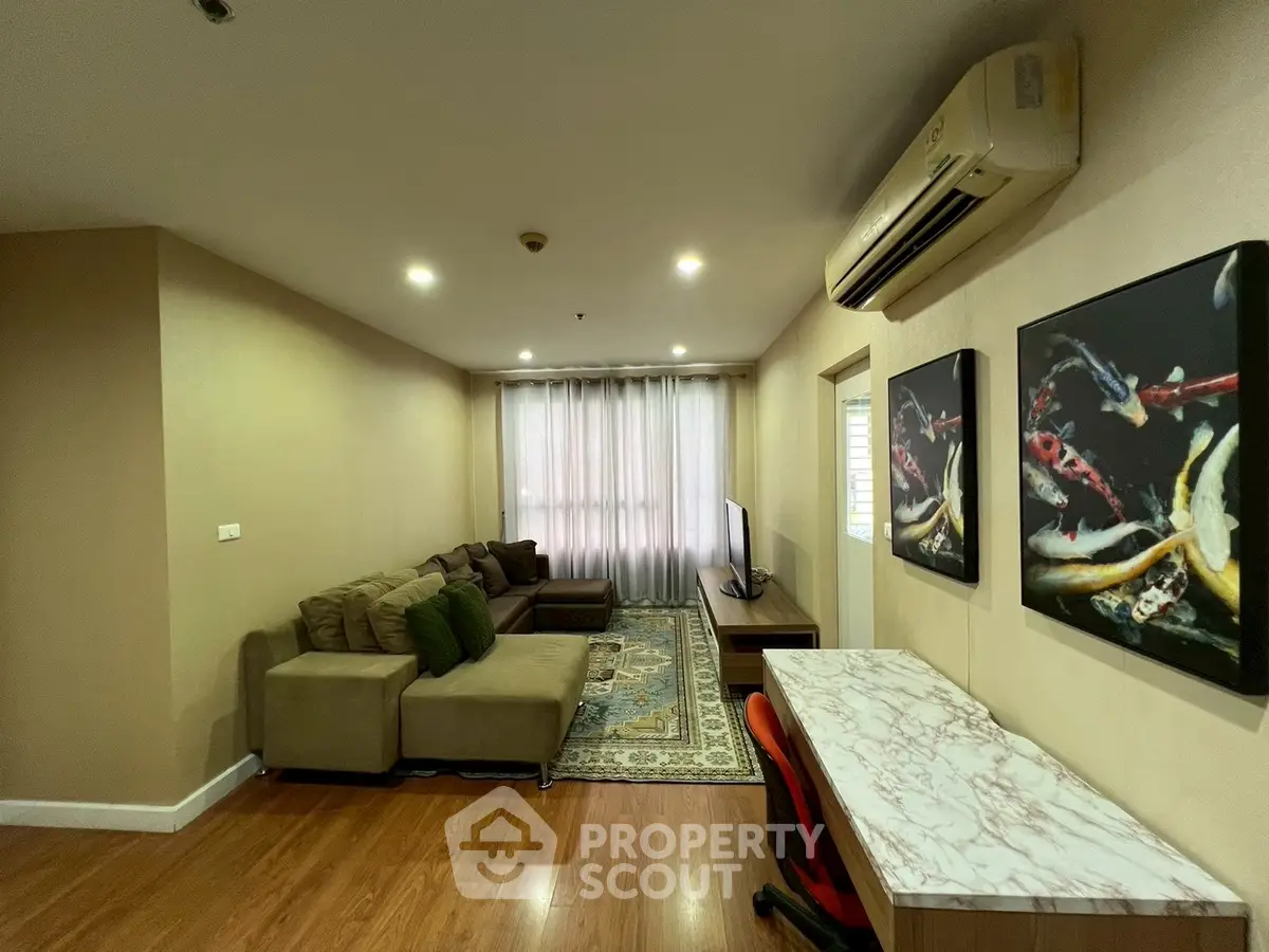 Spacious living room with modern decor and natural light, featuring a cozy sofa and stylish artwork.