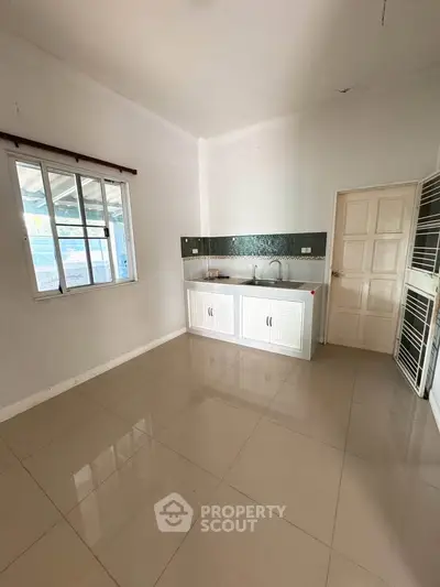 Spacious kitchen with sleek tile flooring and modern cabinetry