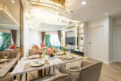 Luxurious open-plan living and dining area with elegant chandelier and modern decor.