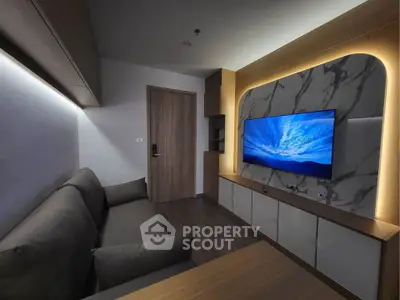 Modern living room with sleek design and wall-mounted TV, featuring stylish lighting and contemporary furniture.