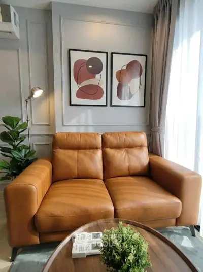 Stylish living room with leather sofa, modern art, and natural light
