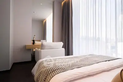 Modern bedroom with elegant decor and large window offering natural light.