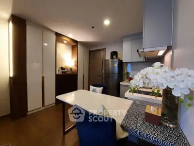 Modern kitchen with sleek cabinetry and dining area, featuring elegant decor and stainless steel appliances.