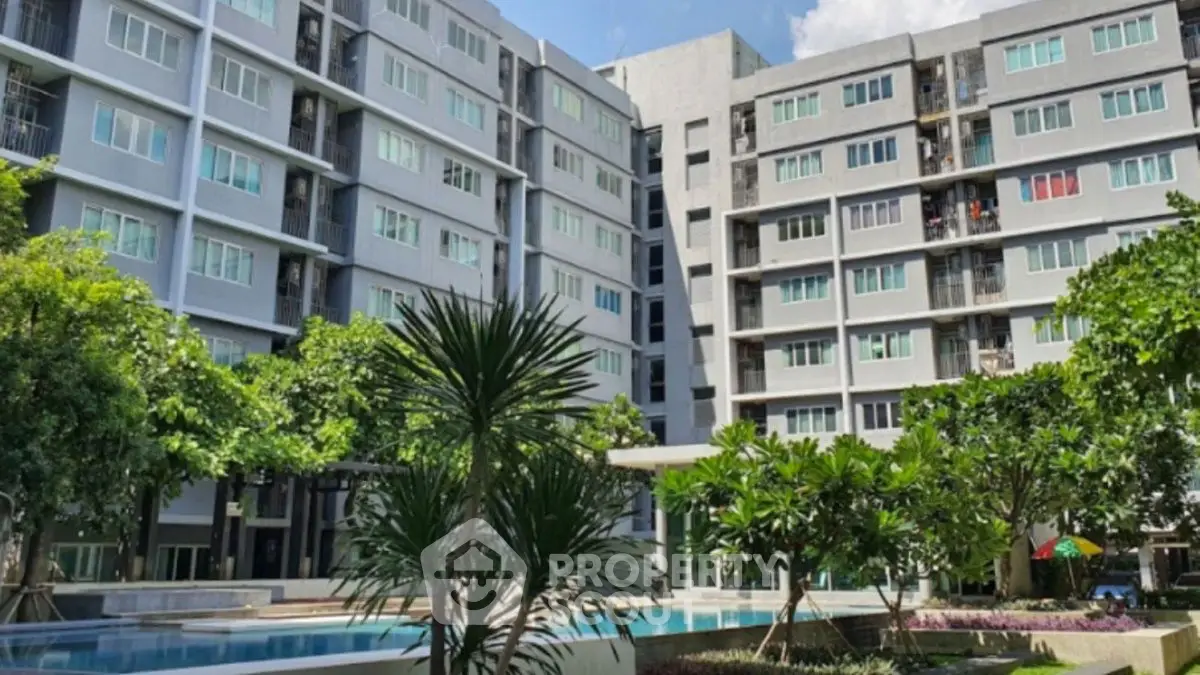 Modern apartment complex with lush garden and inviting pool area.