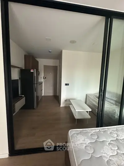 Modern studio apartment with sleek design, featuring a compact kitchen and cozy living area.