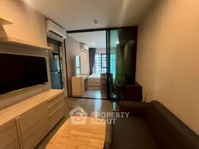 Modern living room with sleek furniture and view into cozy bedroom