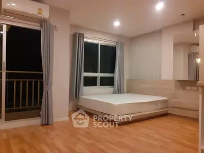 Spacious bedroom with wooden flooring and large window in modern apartment