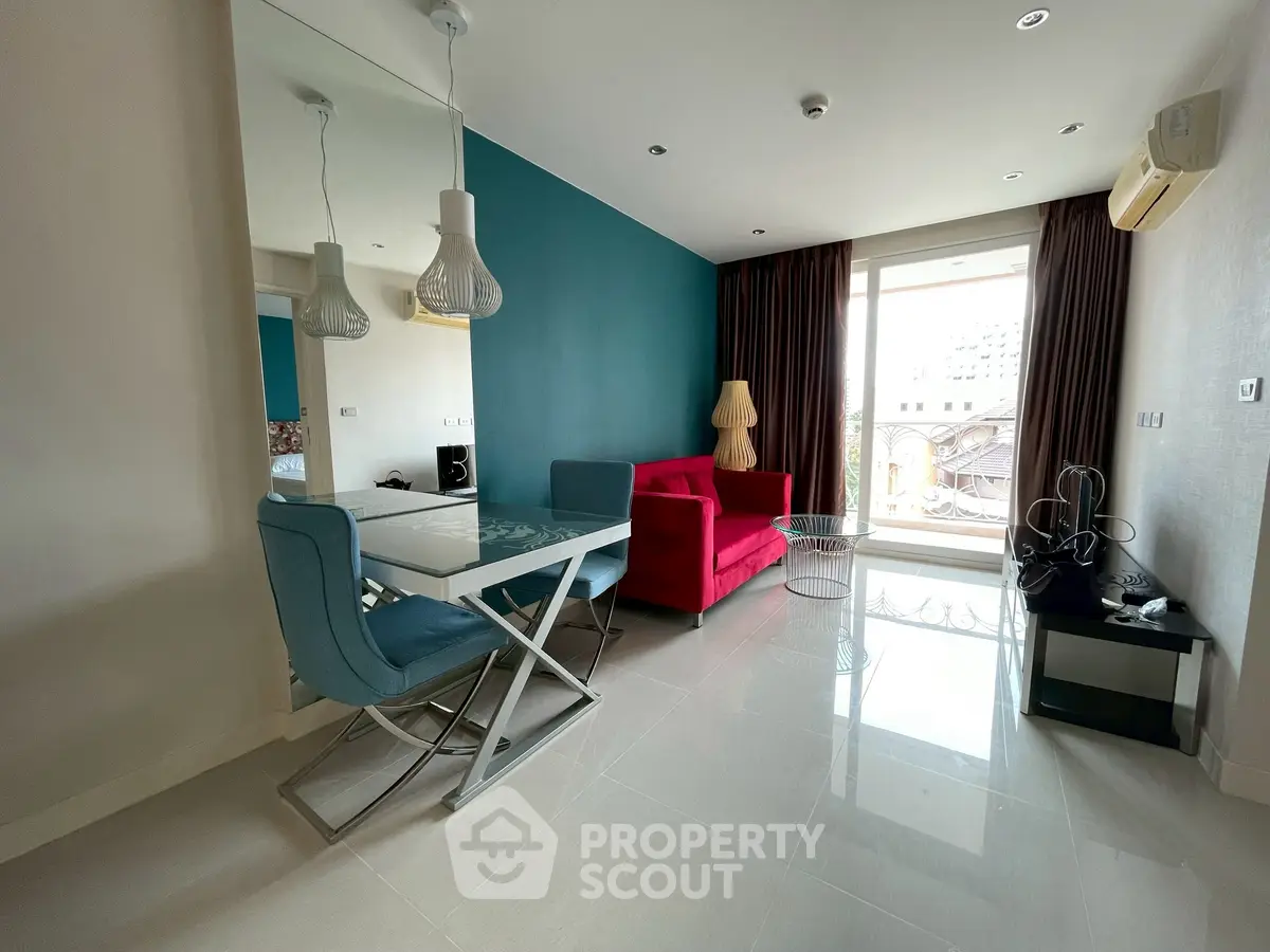 Modern living room with vibrant red sofa and stylish decor in a high-rise apartment.