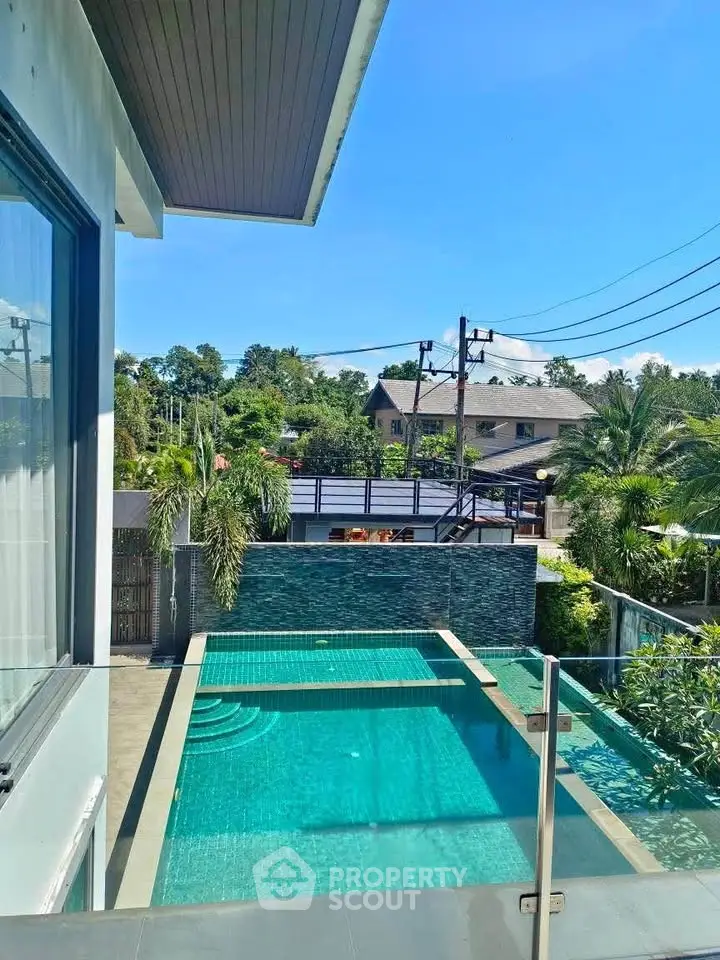 Luxurious modern home with stunning private pool and lush greenery view.
