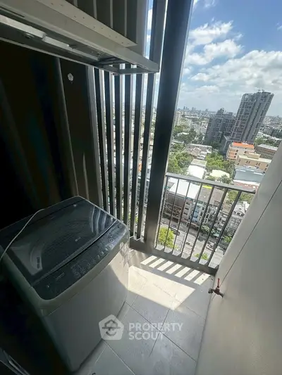 High-rise balcony with washing machine and stunning city view, perfect for urban living.
