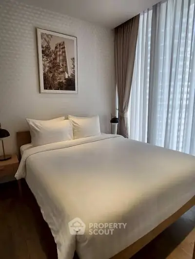 Cozy bedroom with large window and modern decor in a stylish apartment.