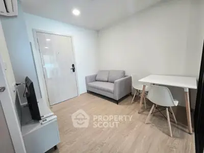 Modern living room with cozy gray sofa and minimalist dining area in a stylish apartment.