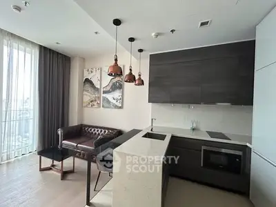 Modern open-layout kitchen and living area with stylish decor and natural light.