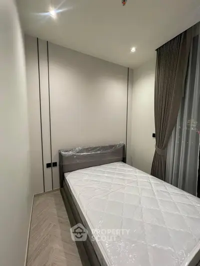 Modern minimalist bedroom with sleek design and large window for natural light.